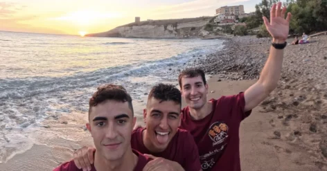 Alessio, Fabio e Gabriele di “Pedalando per bene” con le magliette dell’iniziativa su una spiaggia al tramonto